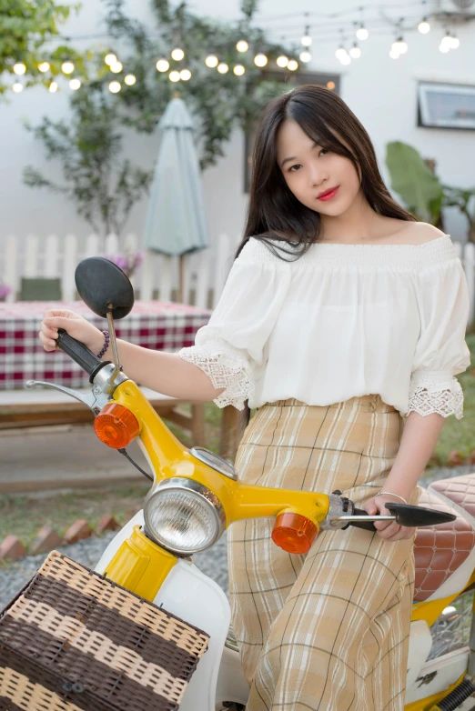 a beautiful young woman sitting on top of a scooter