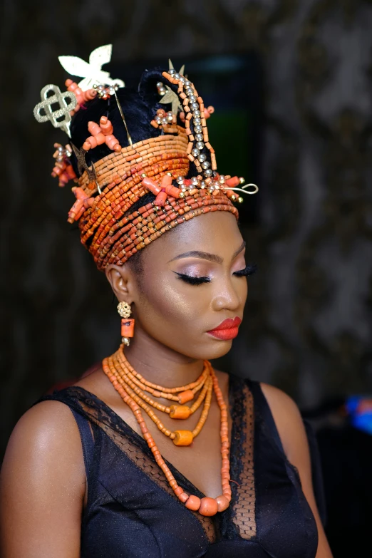 a woman in traditional african dress wearing beaded hair and jewelry