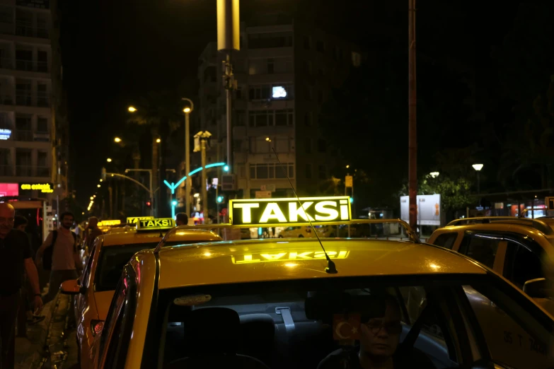 taxis with lights and advertits on the street at night