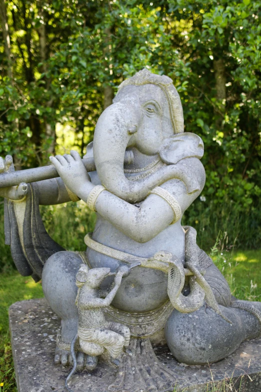 an image of an elephant statue playing the flute