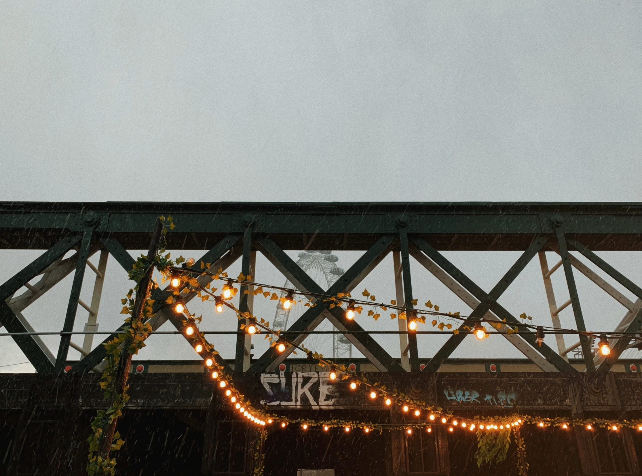 a train traveling over a bridge covered in lights