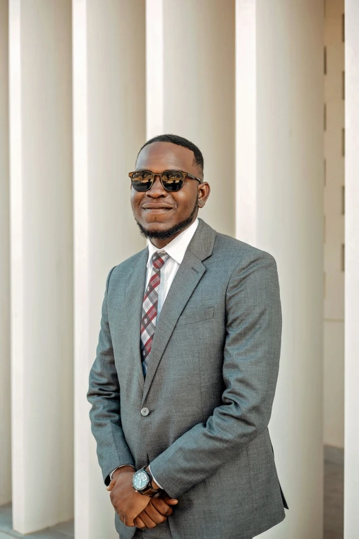 a man wearing a suit, sunglasses, and a neck tie