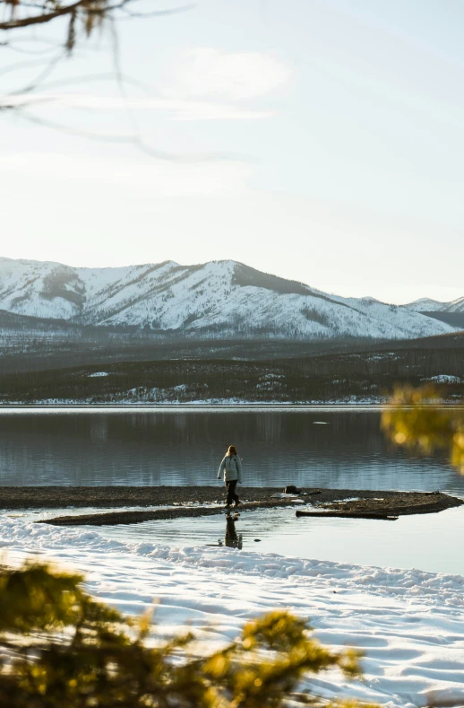 a person fishing in the lake during a winter day