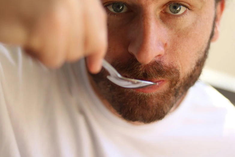 a man brushing his teeth with a toothbrush