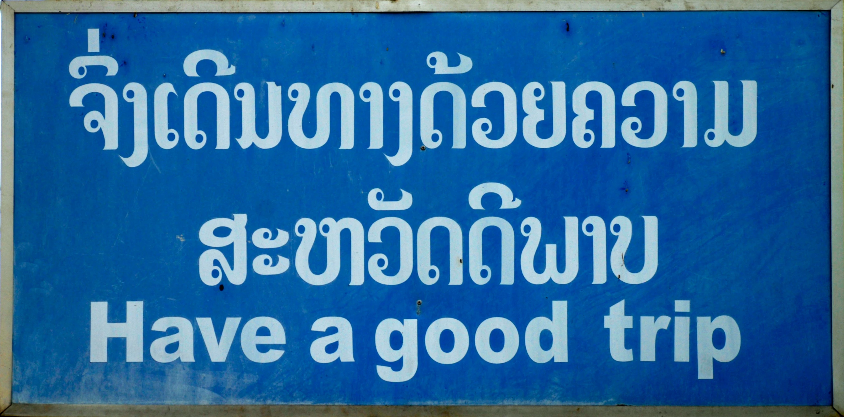 a blue sign with white writing that reads, have a good trip
