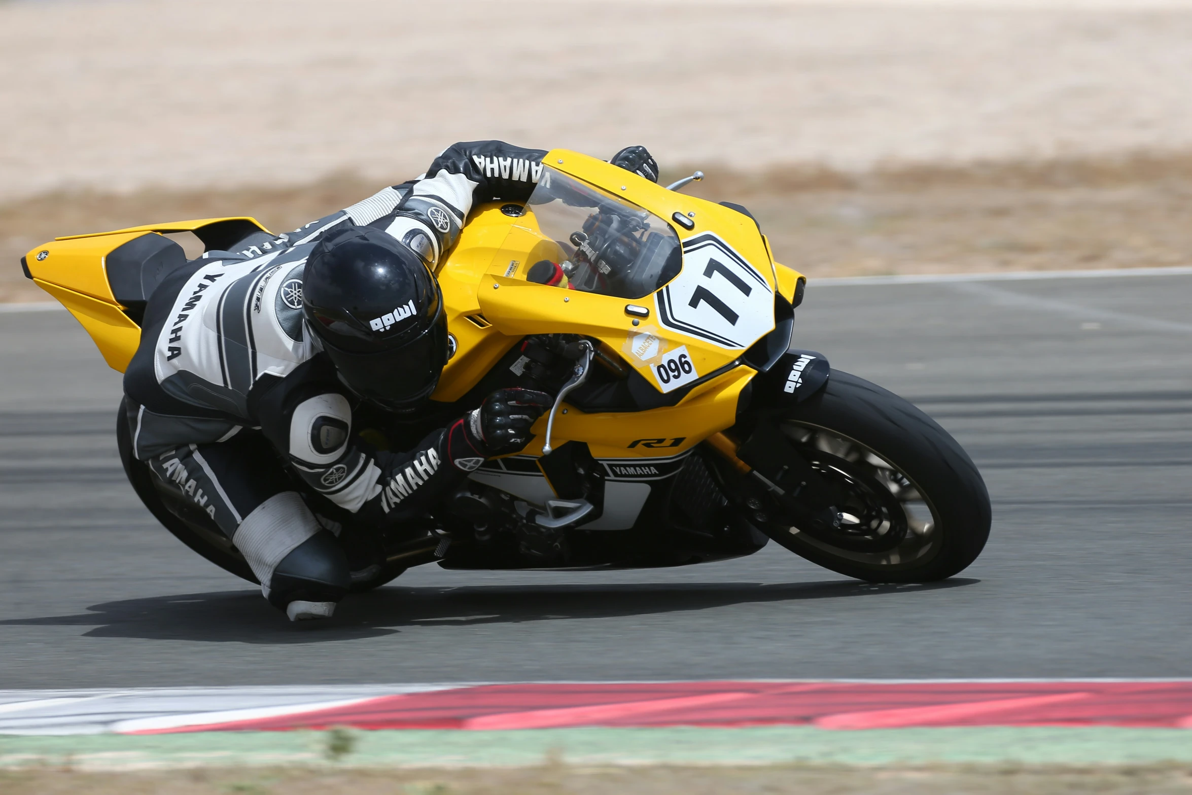 a motorcycle racer leaning into his turn on the road