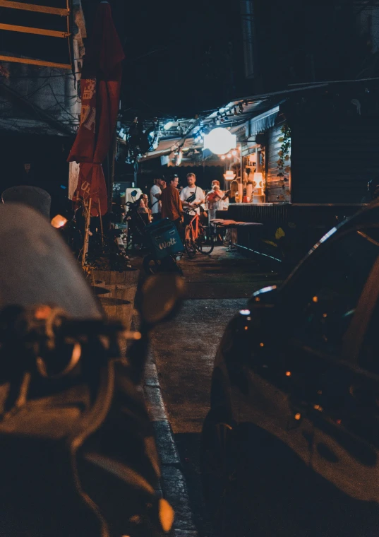 several people sitting at tables outside in the dark