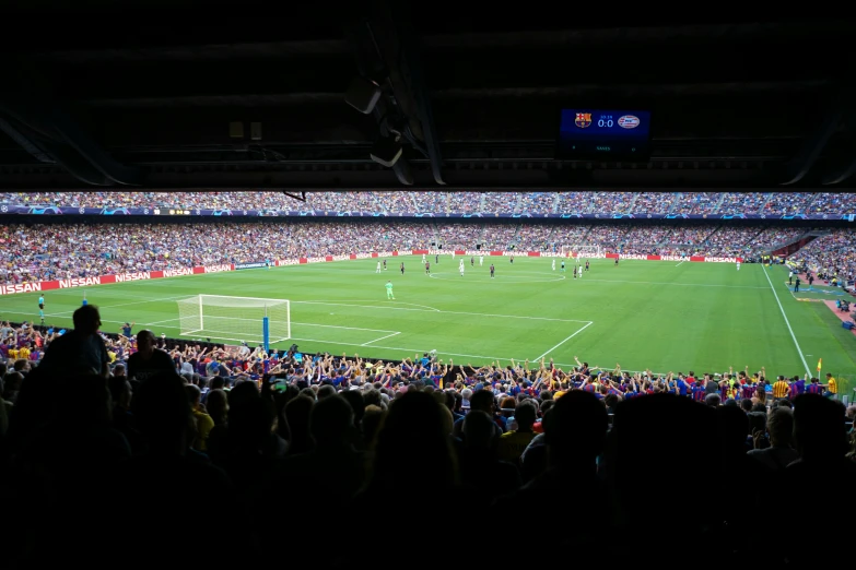 a crowd of people sitting around a soccer field