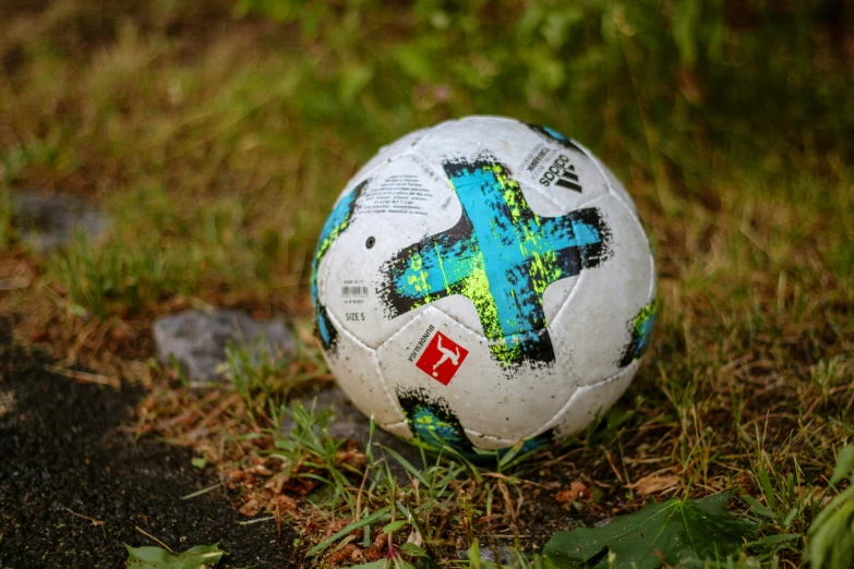 a soccer ball in the grass with graffiti on it