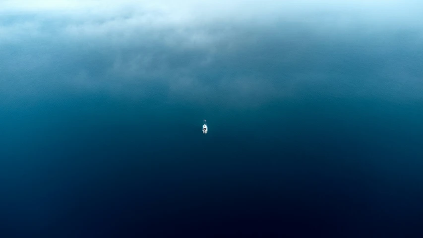 a small kite flying in the sky over water