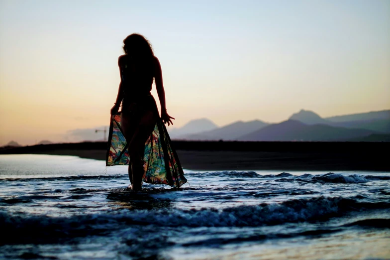 the woman is standing in the water at the beach