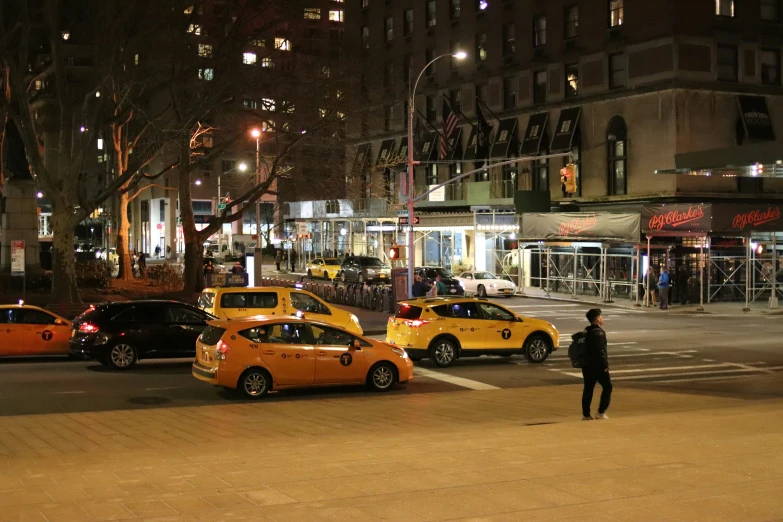 there are many taxis and cars on this city street