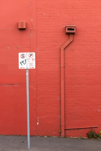 a street sign on a pole near a red building