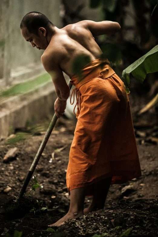 the monk is bending down with his cane