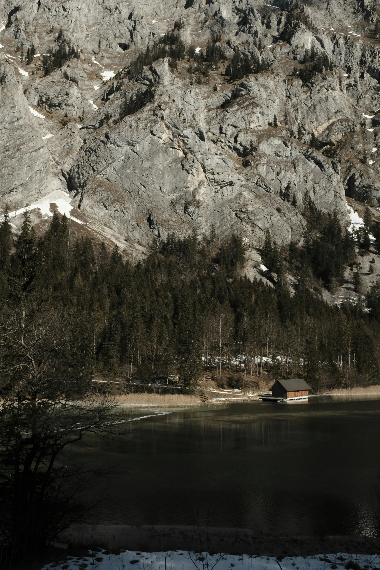 snow covered mountains sit above a small lake