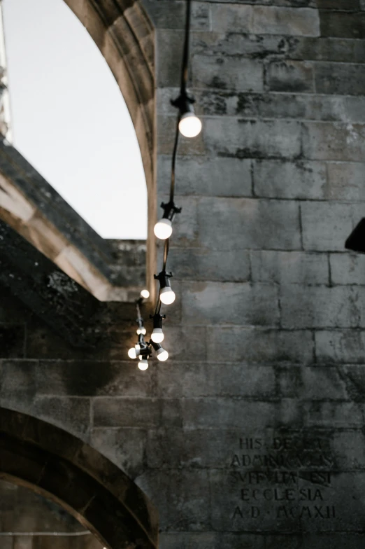 a clock is hanging off of a wall in an old - style building