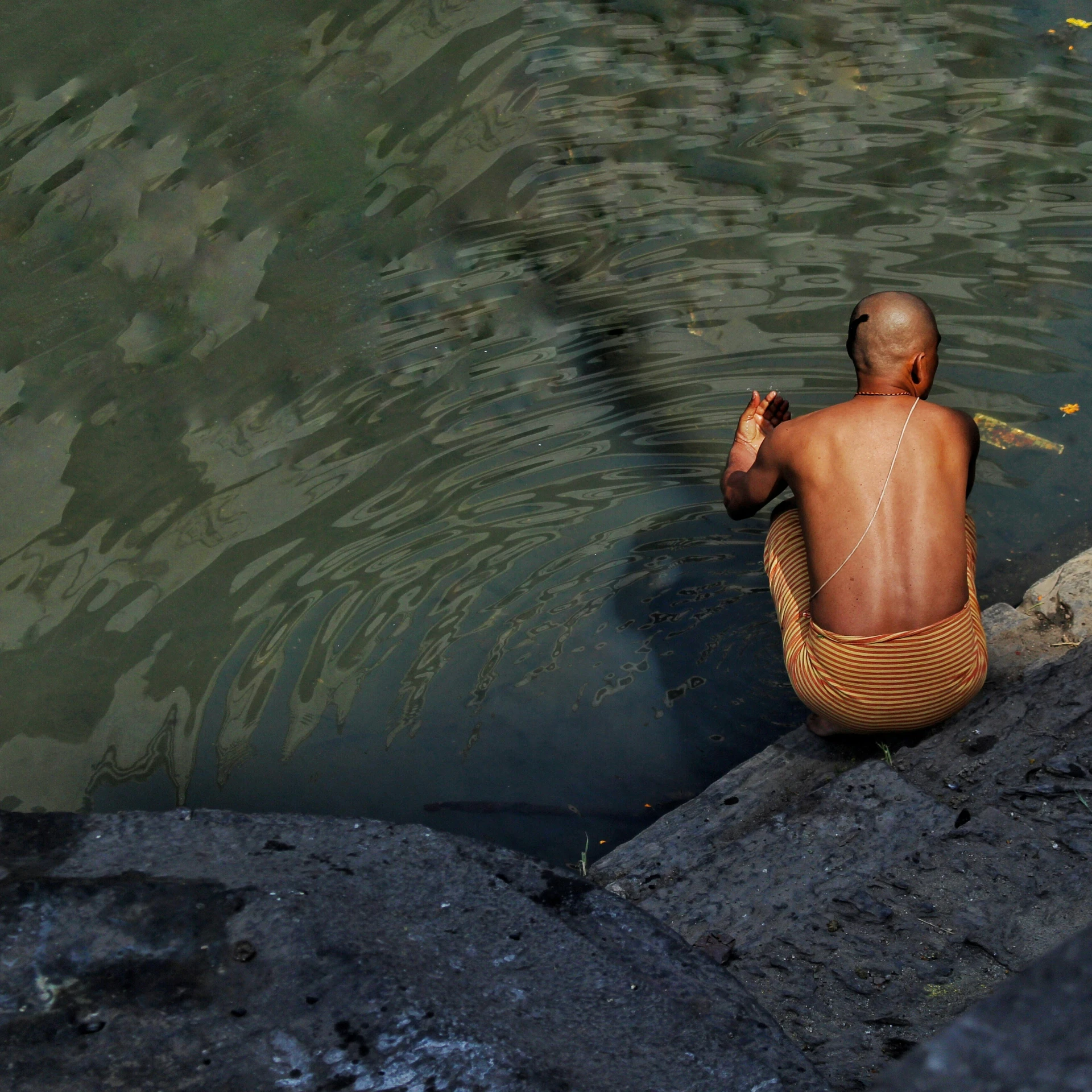 a person sitting in the water by the shore