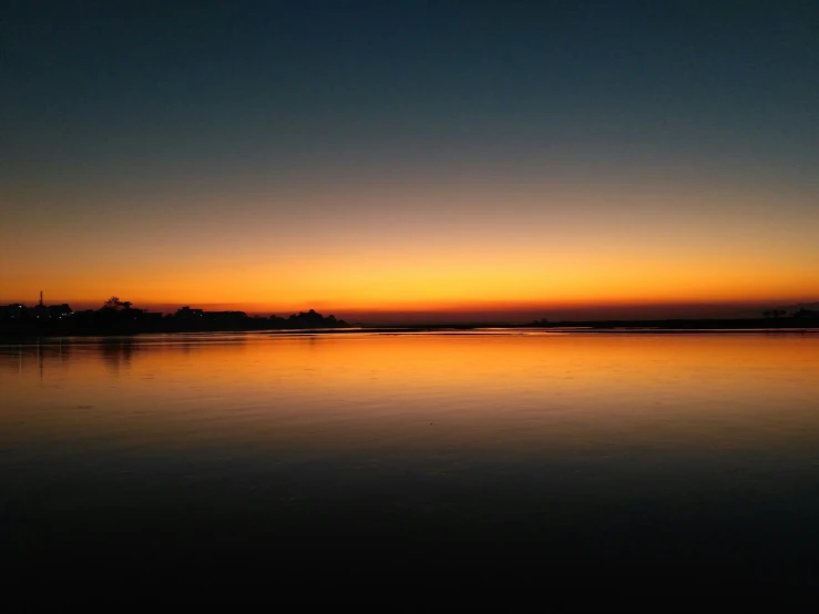 a large body of water sitting under a dark sky