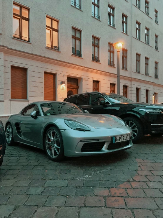 four luxury sports cars line up on a street in front of building