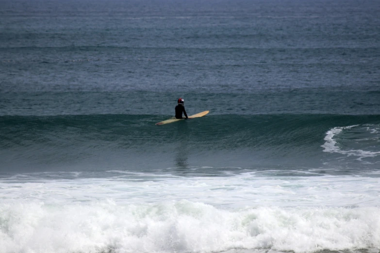 a person riding on top of a wave on a surfboard