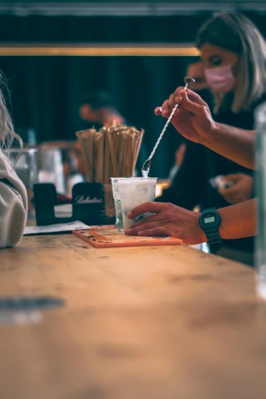 a woman having drinks with another woman behind her