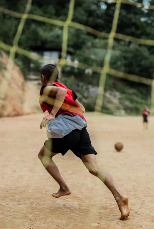 a  playing soccer while a young man watches from behind him