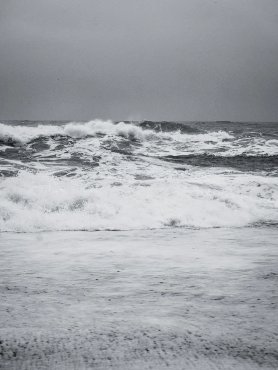 a surfer carrying his board toward shore in the ocean