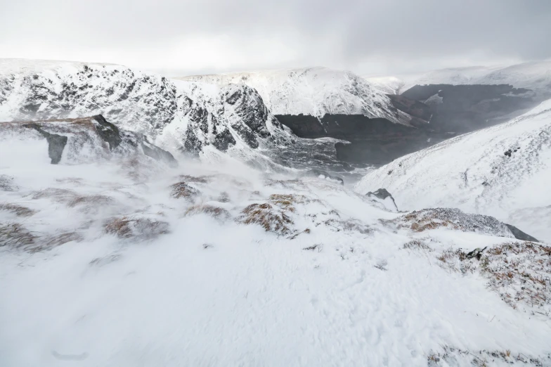 two people with skis going down a mountain covered in snow