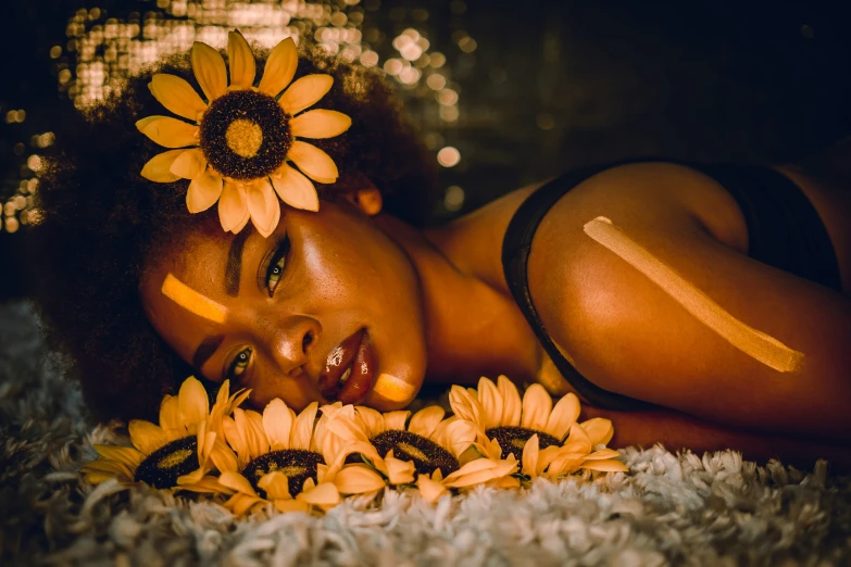 a woman laying on the ground near a flower