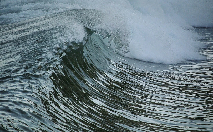 the crest of a wave hitting the water with blue and white waves