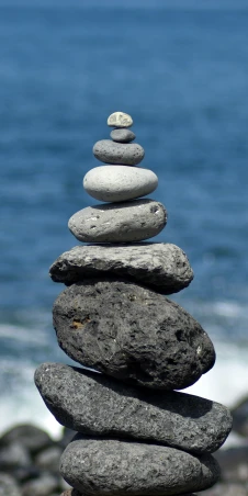stacked rocks near the ocean on top of each other