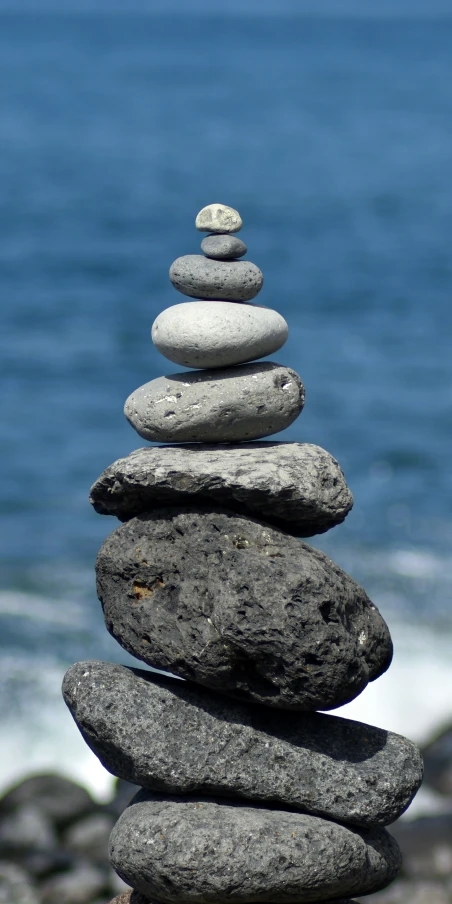 stacked rocks near the ocean on top of each other