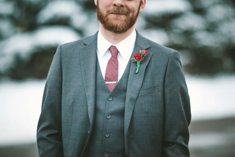 a man wearing a suit and tie with a rose on his lapel