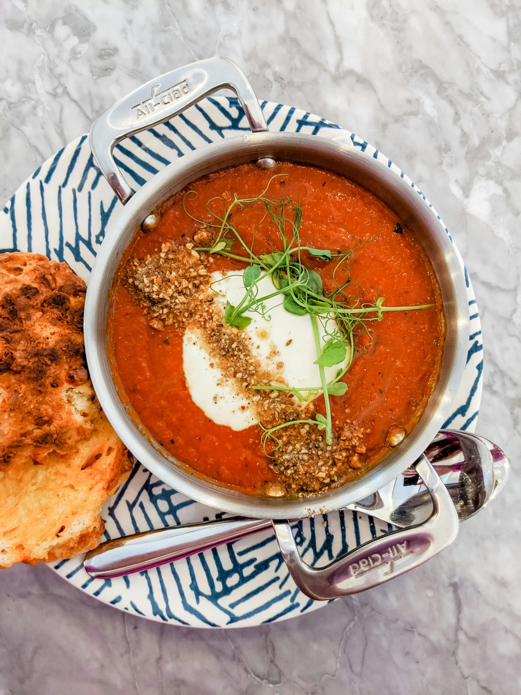 a white plate topped with soup and a piece of bread