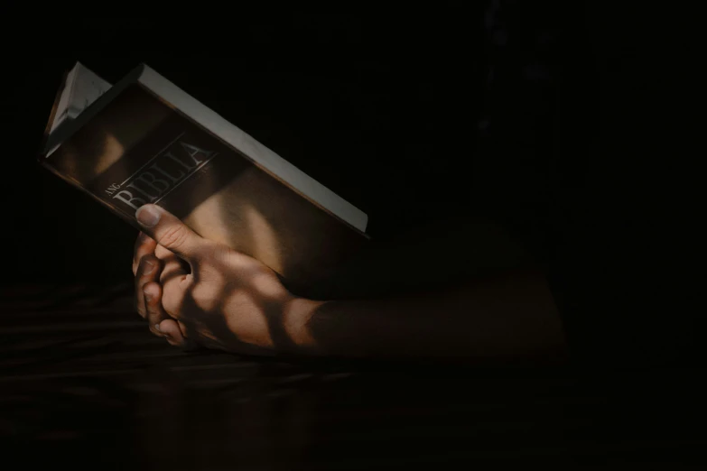 hands are holding up a book on the table