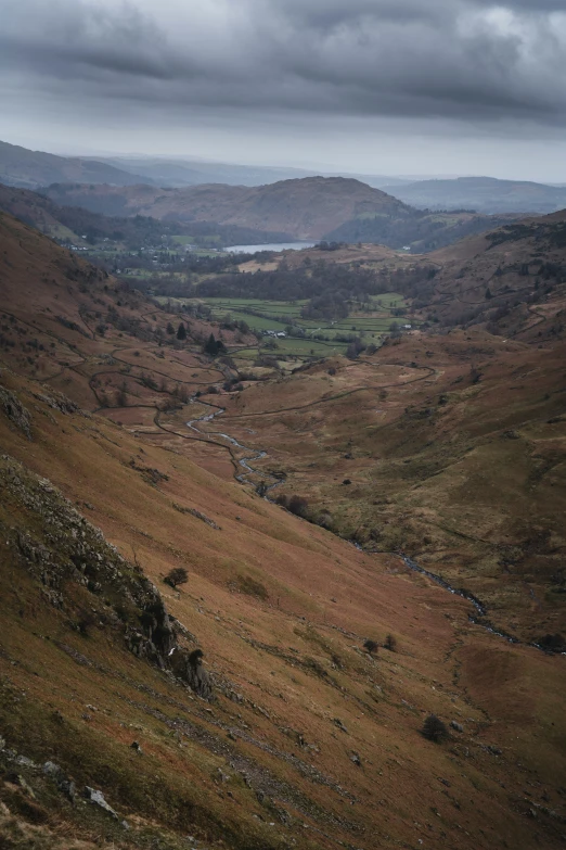 a large grassy valley has rolling hills in the distance