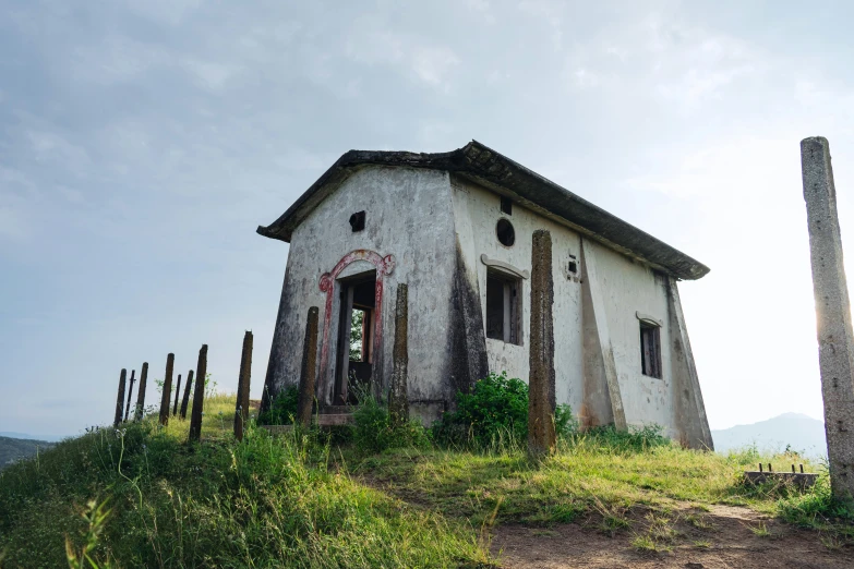 a rundown and abandoned house on a hill