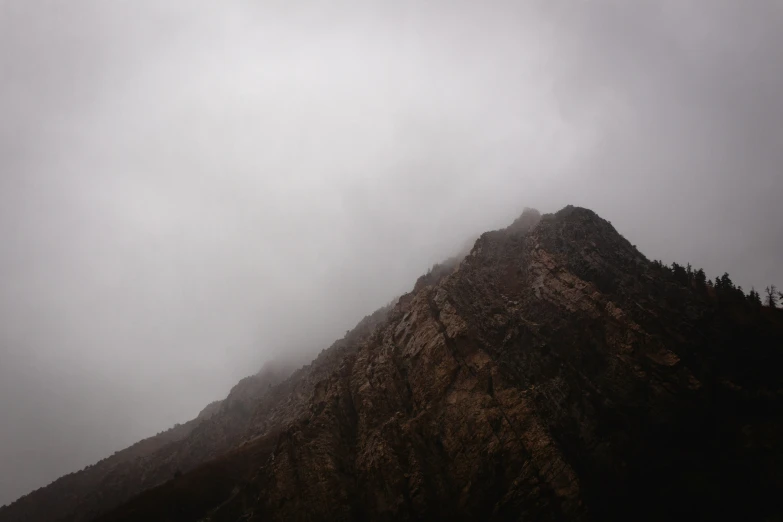 an umbrella on the side of a mountain with fog