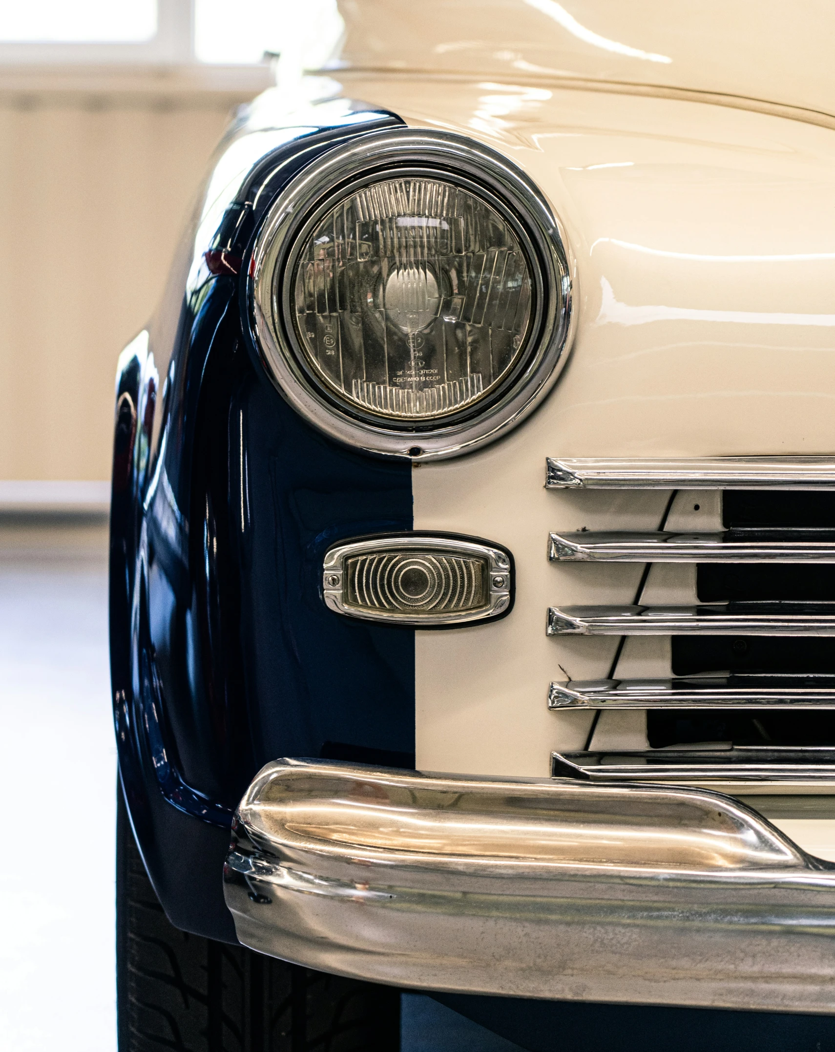 front grill of a classic white car in a showroom