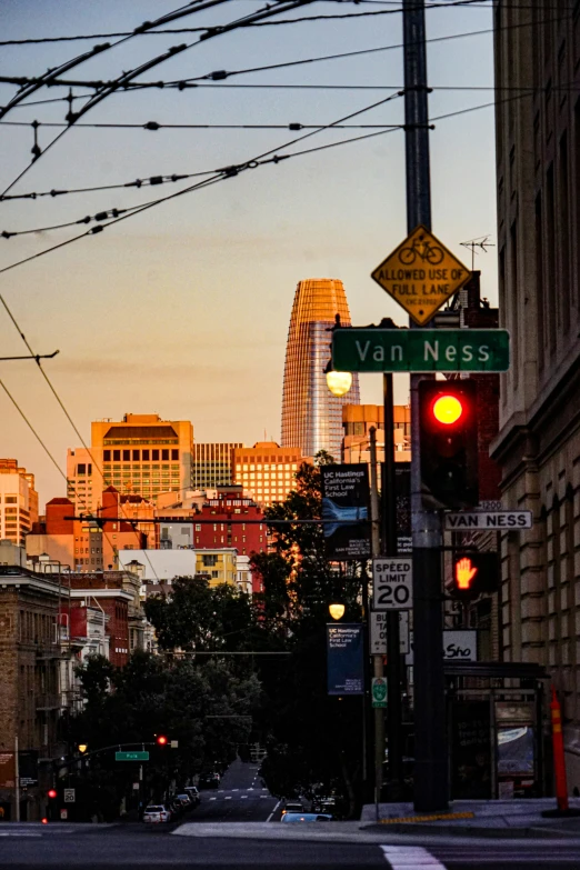 there is a traffic light near buildings with power lines above