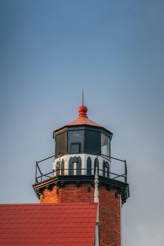 an orange and white lighthouse near some buildings