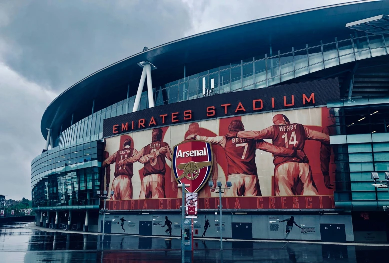 a big stadium with several giant red murals on it