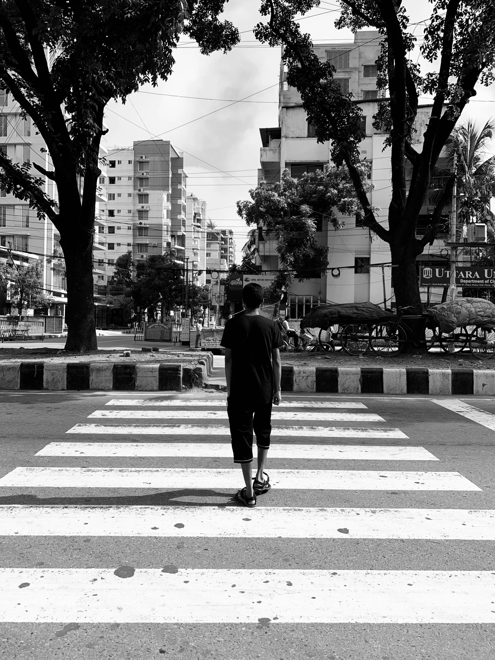 there is a man walking across the crosswalk