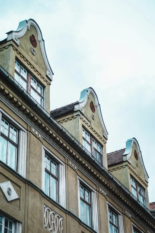 a building with lots of windows sitting below cloudy skies