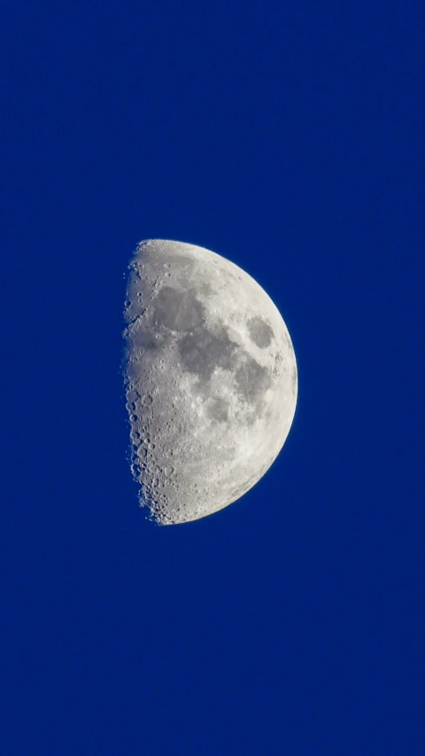 the moon is almost completely covered up against the blue sky