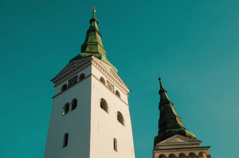 two towers stand near each other against the blue sky