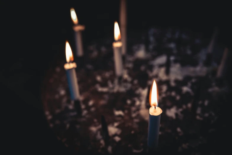 many small candles standing in the dark with some on