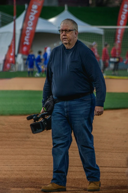 an old man is standing on a baseball field