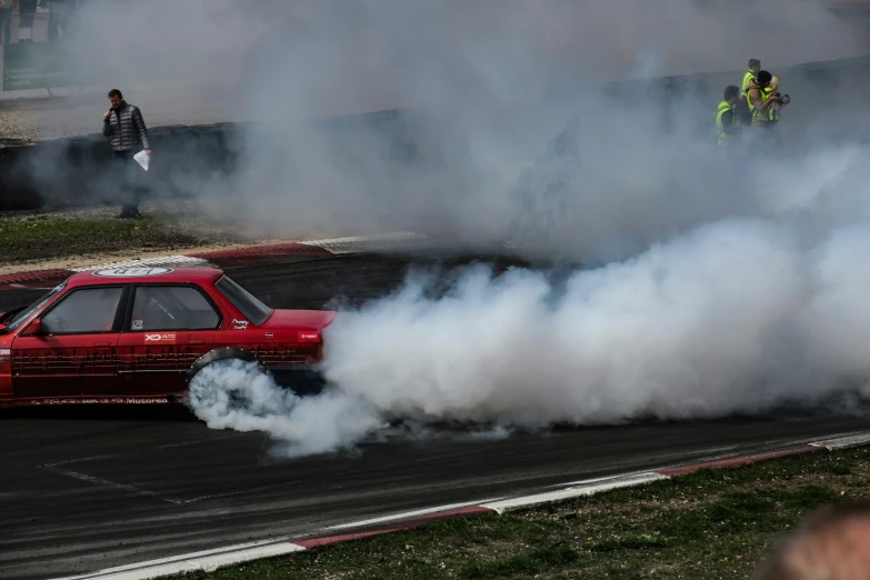 a small car is leaving the track with smoke pouring from the front