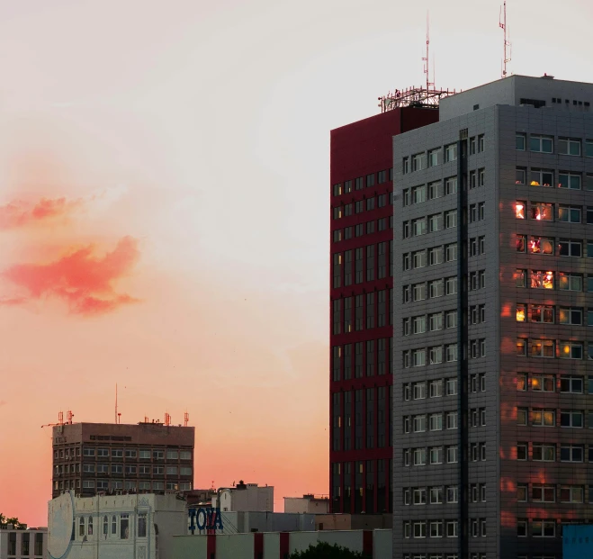 the sun is setting behind some buildings in a city